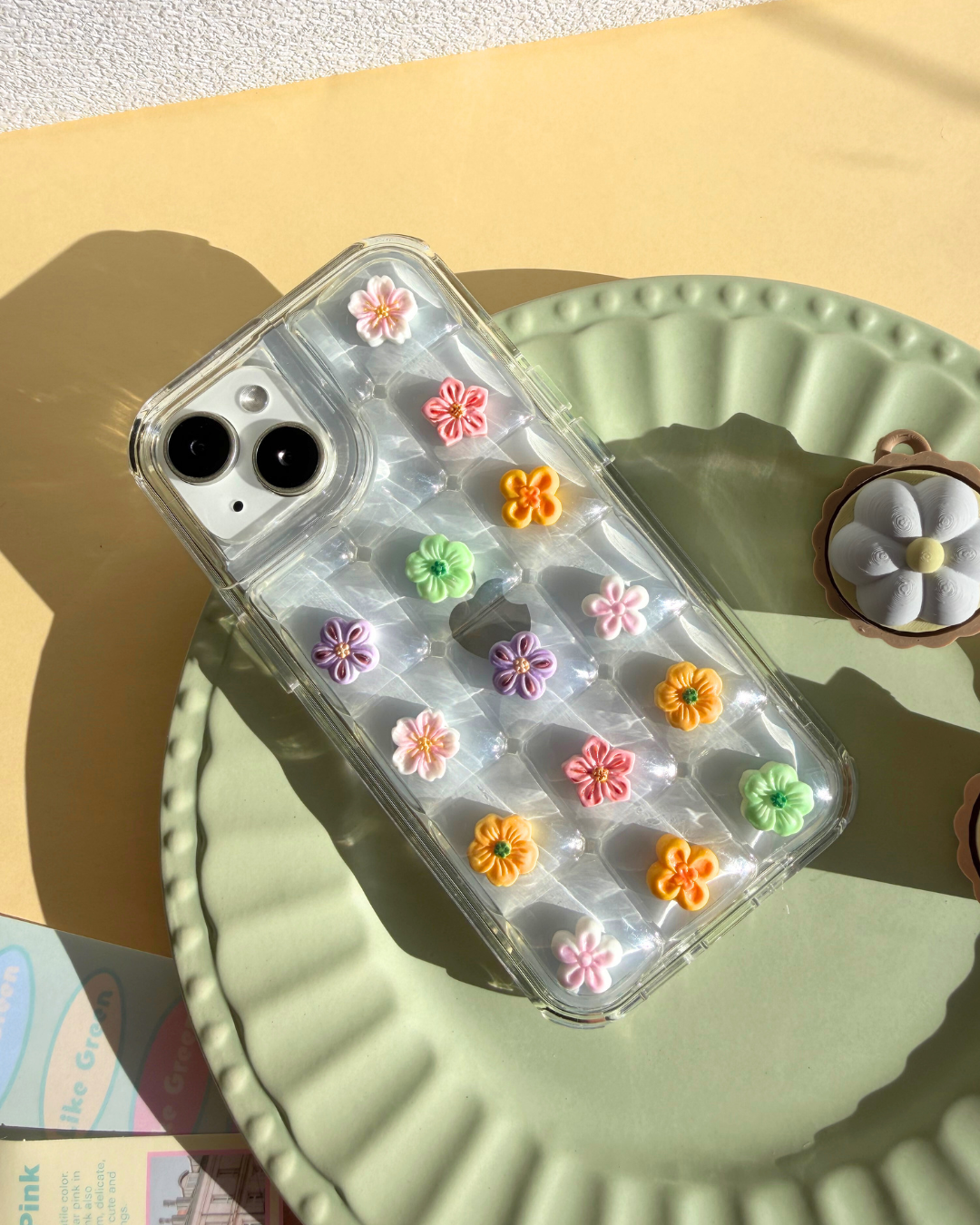 a clear bubble phone case decorated with cute flower charms